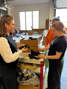Tori Lewis with Hey Girls staff examining products
