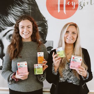 Daisy Williams and Hannah Smith smiling and holding hey girls products in their hands