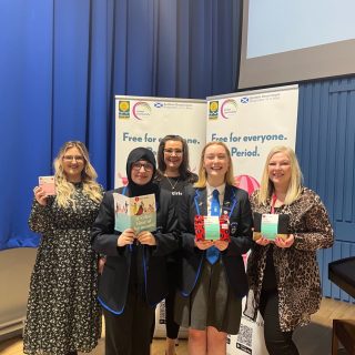 Period dignity event Hollyrood school - group photo with people holding hey girls products